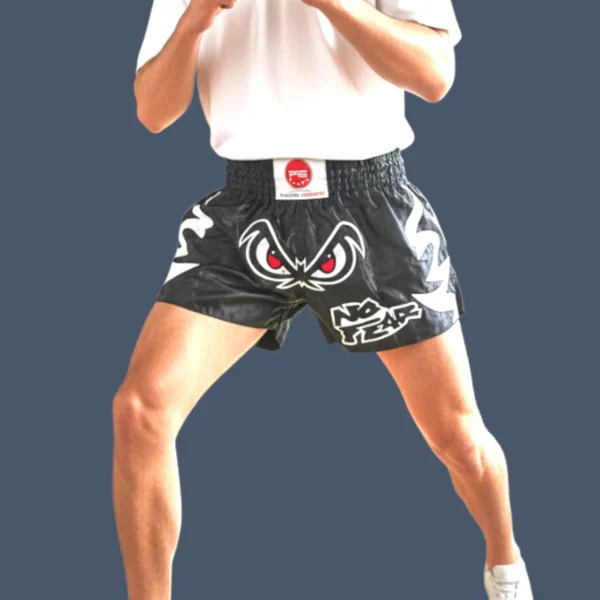 Man wearing Muay Thai shorts featuring 'No Fear' design.
