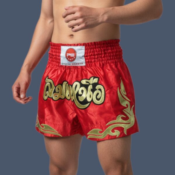 PSK474redgoldonmodel Muay Thai shorts in red and gold design, made in polyester silk. Worn by Muay Thai practitioner