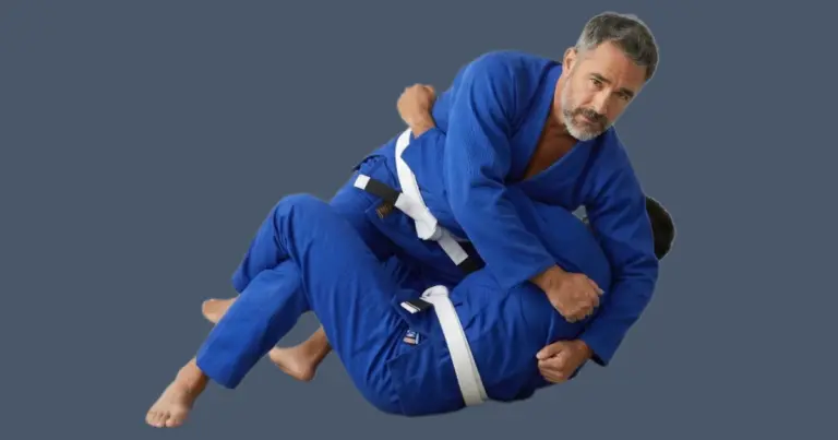 Image shows 2 men practising BJJ wearing blue gis