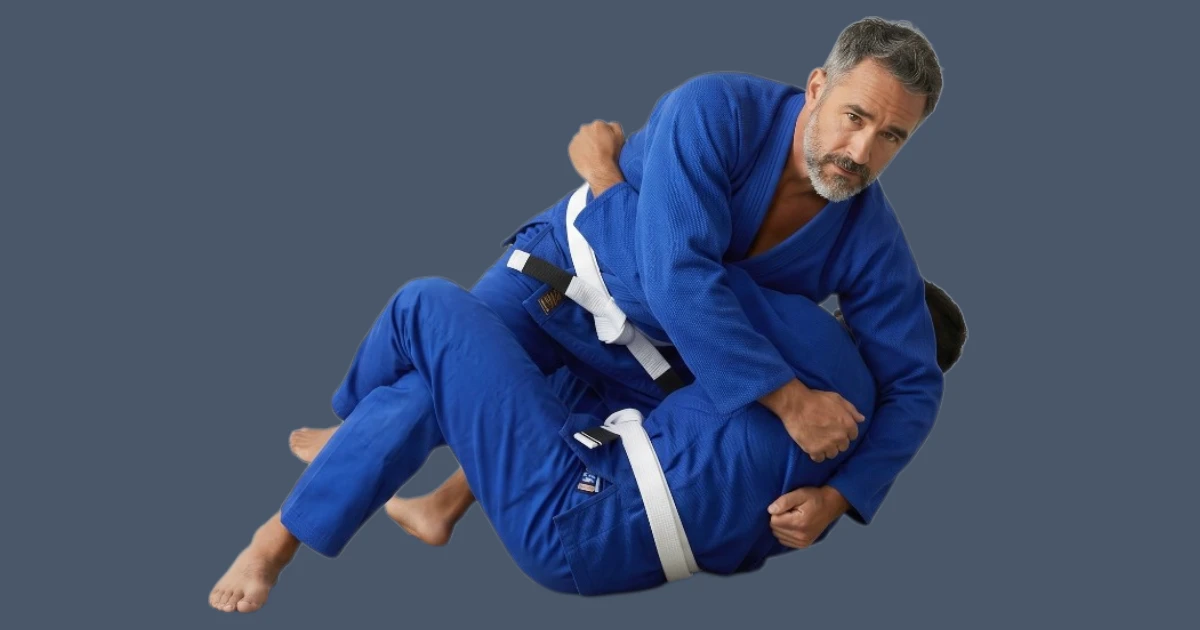 Image shows 2 men practising BJJ wearing blue gis