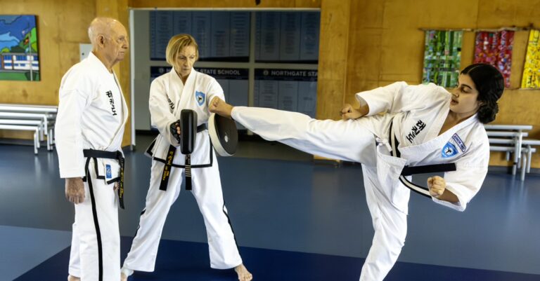 Taekwondo student executing powerful kick into training shield at Pacific International Taekwondo